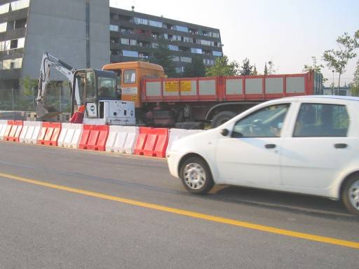 Un auto passa sulla strada, sullo sfondo si notano<br /> i mezzi della PM service e il Garibaldi 2