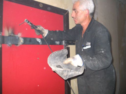 Il fabbro salda una porta al primo piano